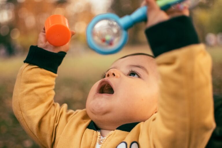 A Baby Wearing Yellow Long Sleeves Busy Playing with His Toys