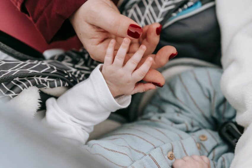 A serene scene depicting a mother tenderly holding her baby's hand, symbolizing love and affection.